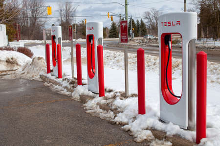 Collingwood, Ontario, Canada - 02-23-2021: Brand new Tesla EV electric car charging Supercharger...
