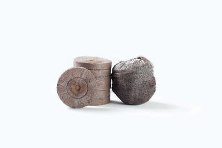 Isolated compacted peat pellets (pod) for seed starting are used by gardeners. Peat is harvested unsustainably and has led to irreversible damage. Coconut coir is a green alternative for germinatingの写真素材