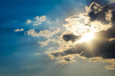Bright sun rays through the clouds with deep blue sky background, creating beautiful scenery の写真素材