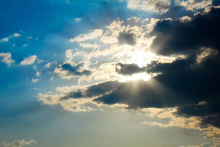 Sun rays behind clouds after a storm の写真素材