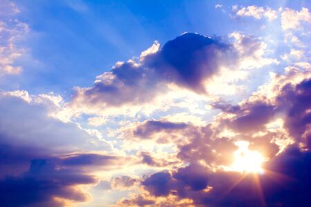 Beautiful colorful sunset with sun rays and blue sky with clouds.の写真素材
