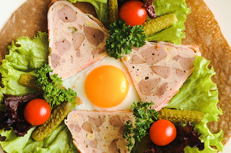 Fried eggs on pancake with vegetables tomato pickles parsley lettuce on and purple basil on plate. Colorful breakfast with egg and vegetables on pancake.の写真素材