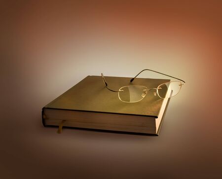 Glasses lying on the old  bookの写真素材