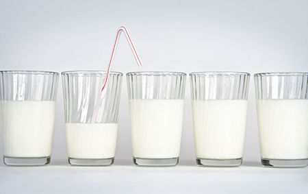 Five glasses on a white background with milkの写真素材