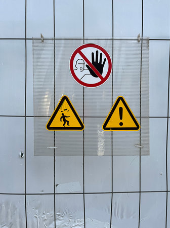Safety sign on a construction barrier showing three warnings: â€œNo entry without...