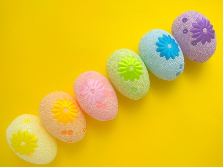 Six colorful easter eggs on a yellow background