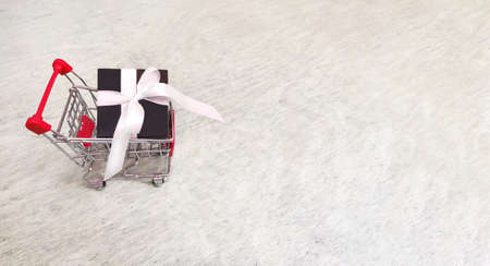 gift brown box with satin tape in a shopping cart. Copy spaceの写真素材