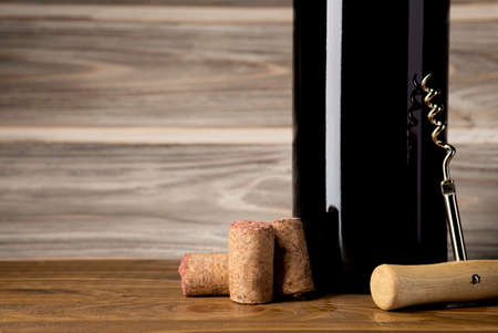 bottle, corkscrew and cork are on the table