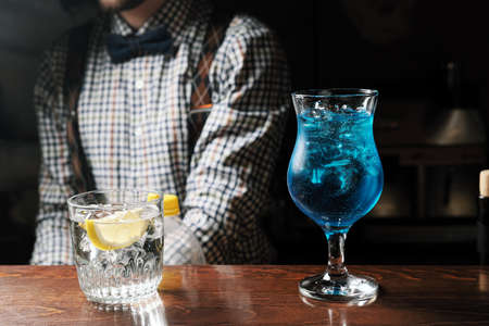Glasses of cocktails blue vodka on bar backgroundの写真素材