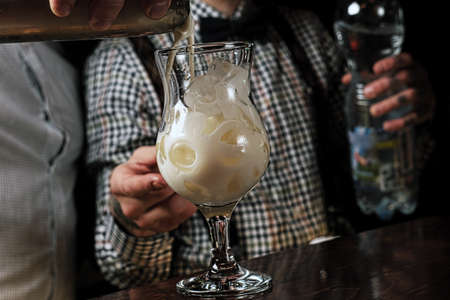 Pouring milk in iced coffee on grey backgroundの写真素材