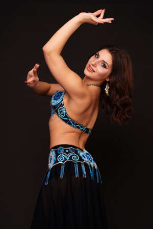 Beautiful belly dancer perfoming exotic dance in red flutter dress artの写真素材