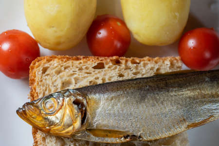 smoked sprat fish on bread home-style white plateの写真素材