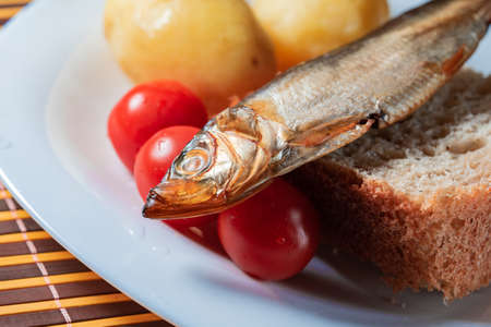 smoked sprat fish on bread home-style white plateの写真素材
