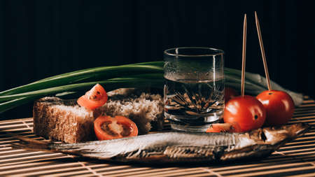 still life alcoholic vodka fish tomato green onionsの写真素材