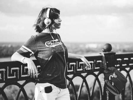 Serene girl standing alone on waterfront in front of fence of embankment. Nizhniy Novgorod.のeditorial素材