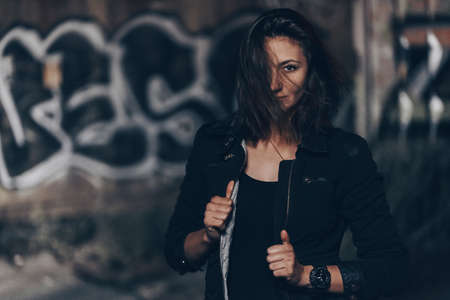 Mysterious beautiful woman in black bodysuit and leather jacketの写真素材