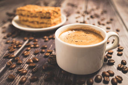 Honey cake and a cup of coffee on a wooden table art.の写真素材