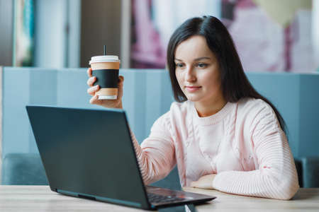 Girl freelancer at a laptop with coffee.の写真素材