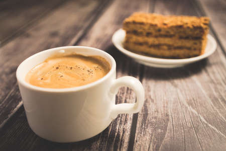 Honey cake and a cup of coffee on a wooden tableの写真素材