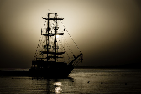 Beautiful sunset over the sea. Sailboat in the bay. Toning. Stylization. Vignetting. の写真素材