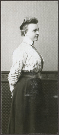 ROSTOCK, GERMANY - CIRCA 1905: A vintage portrait of young woman, standing half-turned to the wall, dressed in a blouse and long skirt, circa 1905 のeditorial素材