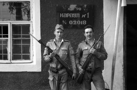 MOSCOW REGION, RUSSIA - CIRCA 1993: A soldiers posing with guns. The inscription in Russian: Russian Defence Ministry. Guard â1, the number of military unit 02018. Film scan. Large grain, circa 1993 のeditorial素材