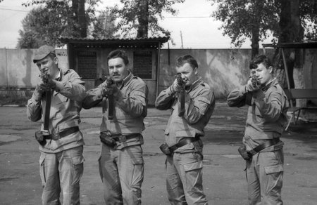 MOSCOW REGION, RUSSIA - CIRCA 1993: Soldiers posing with guns. Preparations for shooting. Film scan. Large grain, circa 1993 のeditorial素材