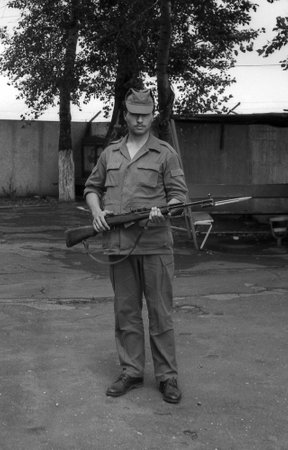 MOSCOW REGION, RUSSIA - CIRCA 1993: A soldier posing with guns. Film scan. Large grain, circa 1993 