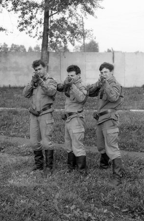 MOSCOW REGION, RUSSIA - CIRCA 1993: Soldiers posing with guns. Preparations for shooting. Film scan. Large grain, circa 1993のeditorial素材