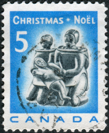 CANADA - CIRCA 1968: Postage stamp printed in Canada, Christmas Issue, shows Eskimo soapstone carving: Eskimo Family, circa 1968のeditorial素材