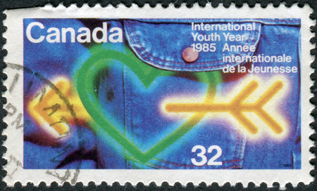 CANADA - CIRCA 1985: Postage stamp printed in Canada, dedicated to International Youth Year, shows the Heart, arrow, jeans, circa 1985のeditorial素材