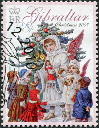 GIBRALTAR - CIRCA 2005: A stamp printed in Gibraltar, is devoted to Christmas, shows an angel, a Christmas tree and children, circa 2005のeditorial素材