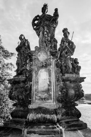Sculpture of Saint Barbara, Saint Margaret and Saint Elizabeth on the Charles Bridge in Prague. Czech Republic. Black and whiteの写真素材