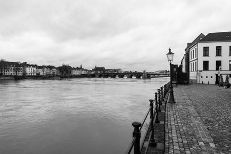 MAASTRICHT, NETHERLANDS - JANUARY 09, 2015: View of Maastricht city centre with its partly medieval bridge on the Meuse river. Black and white. Maastricht is the oldest city of the Netherlands and the capital city of the province of Limburg.のeditorial素材