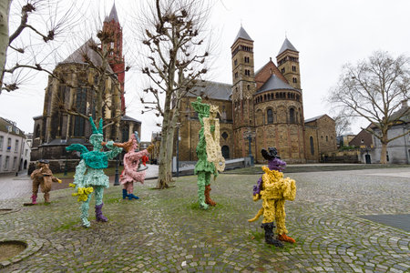 MAASTRICHT, NETHERLANDS - JANUARY 09, 2015: Vrijthof square. People and animals in stone and bronze ('t Zaat Herremenieke) by Han van Wetering. Sculpture dedicated to the carnival. In the background Evangelical Church of St. John and Basilica of St. Servaのeditorial素材
