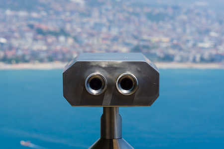 Binoculars. In the background the outline of the city and the turquoise sea.の写真素材