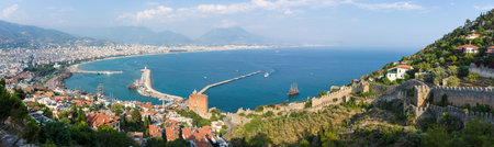 Panoramic view of sea port of Alanya. In the foreground the ruins of an ancient fortress. In the background of the Taurus mountains and residential neighborhoods of Alanya. Turkey.のeditorial素材