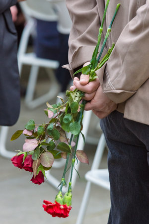 BERLIN - MAY 08, 2015: Victory in Europe Day. Treptower Park. Female hand holding red roses.のeditorial素材