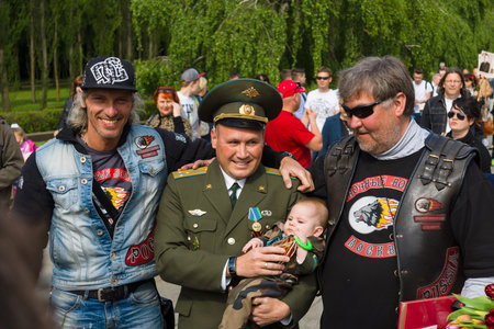 BERLIN - MAY 09, 2015: Victory Day in Treptower Park. Russian officer holding a baby is photographed with bikers from the club "Night Wolves". Moscow. Russia.のeditorial素材