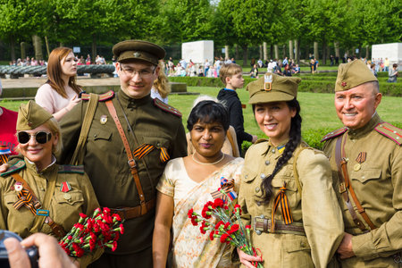BERLIN - MAY 09, 2015: Victory Day in Treptower Park. Group of soldiers in the form of the Red Army and the Polish Army, photographed with a woman.のeditorial素材