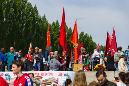 BERLIN - MAY 09, 2015: Victory Day in Treptower Park. Visitors to the memorial with Soviet flags and...