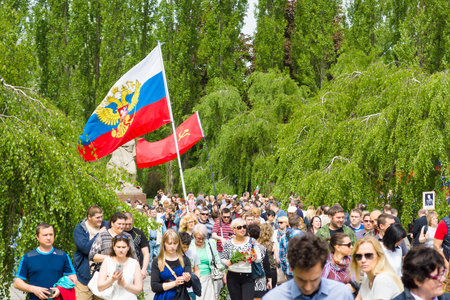 BERLIN - MAY 09, 2015: Victory Day in Treptower Park. Visitors to the memorial with the flags of the USSR, Russia and patriotic slogans.のeditorial素材