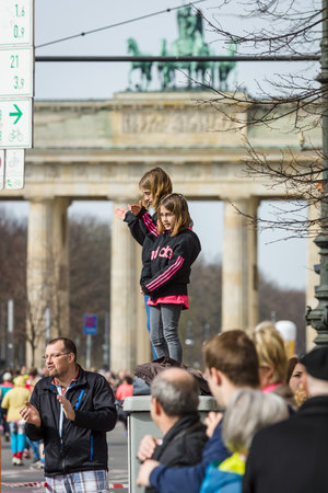 BERLIN - APRIL 03, 2016: The annual Berlin Half Marathon. Two girls watching a marathon against the backdrop of the Brandenburg Gate.のeditorial素材