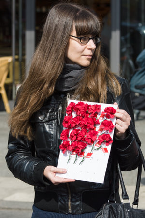 BERLIN - MAY 01, 2016: Woman with flowers (lapel badge). Members of trade unions, workers and employees at the demonstration on the occasion of Labour day.のeditorial素材