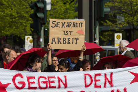BERLIN - MAY 01, 2016: The woman with the poster "Sex work is work". Members of trade unions, workers and employees at the demonstration on the occasion of Labour day.のeditorial素材