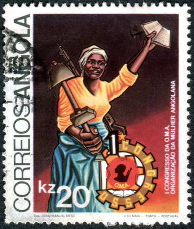 ANGOLA - CIRCA 1983: A stamp printed in Angola, dedicated to 1st Congress of O.M.A. - Organization of Angolan Women, shows a woman with a shovel and a weapon, circa 1983のeditorial素材