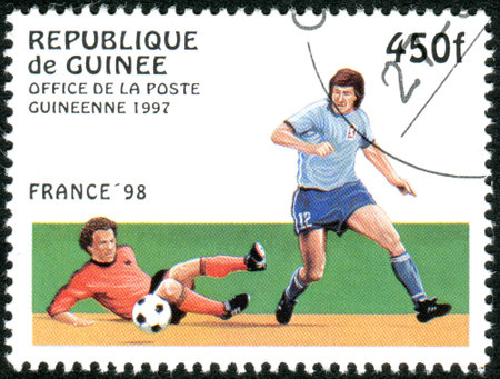 GUINEA - CIRCA 1997: A stamp printed in Guinea dedicated to the FIFA World Cup 1998 - France, shows the Game scene, circa 1997のeditorial素材