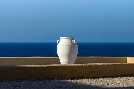 Typical view of the Mediterranean region. Decorative white amphora on a background of blue sky and...