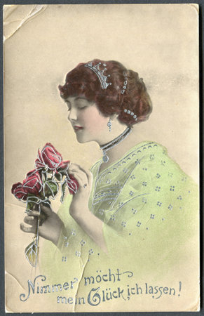 GERMANY - CIRCA 1917: A postcard printed in Germany, shows a portrait of a beautiful woman with roses. The inscription in German: Never want to leave my happiness!, circa 1917のeditorial素材
