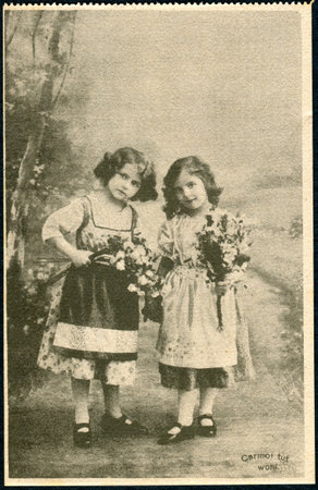 GERMANY - CIRCA 1914: A promotional postcard (Carmol tut wohl) printed in Germany, shows two little girls with bouquets of flowers, circa 1914のeditorial素材
